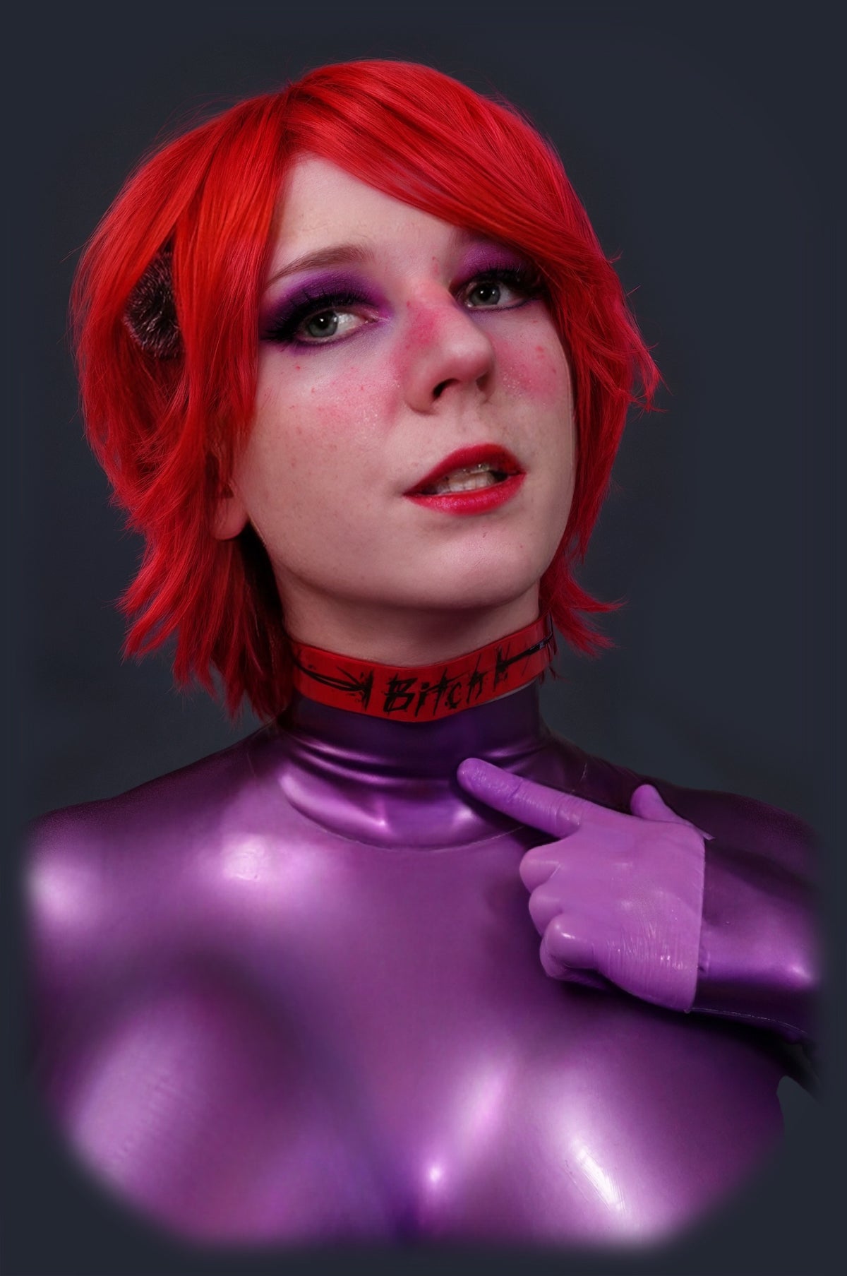 Red latex collar and choker on a purple latex catsuit, front pose